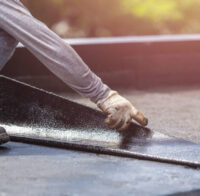 Asia worker installing tar foil on the rooftop of building. Waterproof system by gas and fire torching