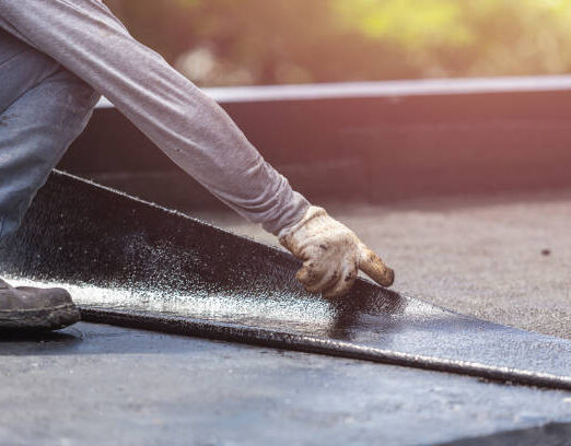 Asia worker installing tar foil on the rooftop of building. Waterproof system by gas and fire torching